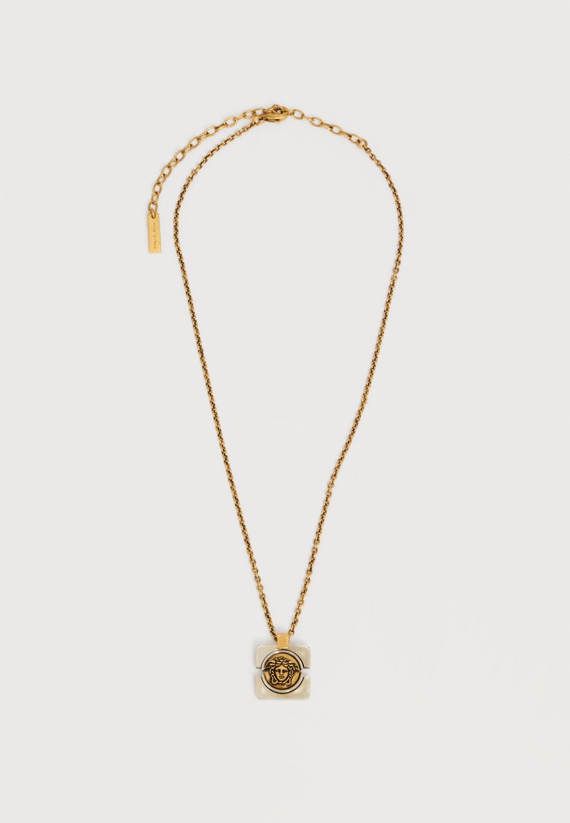 Χρυσή αλυσίδα με τετράγωνο μενταγιόν που φέρει ανάγλυφη κεφαλή Μέδουσας στο κέντρο.
