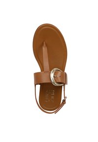 Sandalo in pelle marrone con suola piatta, fascia tra le dita e ampia cinghia alla caviglia con fibbia metallica circolare. Texture liscia in tutto il sandalo.