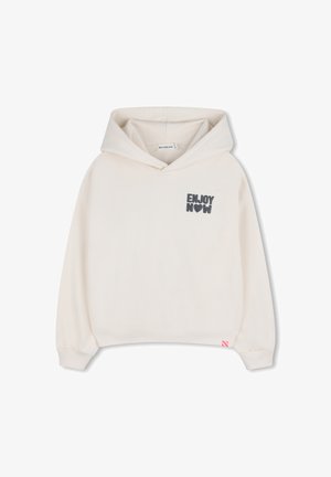 Sweat à capuche de couleur crème avec poignets et ourlet côtelés, présente le texte « ENJOY NOW » en imprimé gris foncé sur le devant, fabriqué en tissu doux.