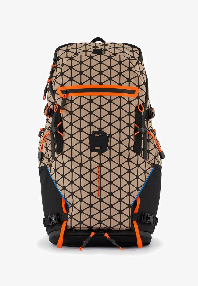 Sac à dos avec un motif géométrique beige et noir, des accents orange, plusieurs sangles, une poche avant, et une section inférieure noire.