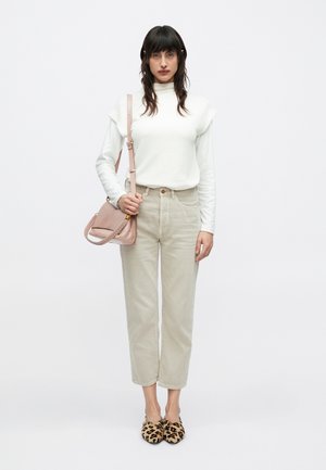 Ελαφρύ λευκό πλεκτό πουλόβερ, μπεζ παντελόνι ψηλόμεσο, μπαλαρίνες με λεοπάρ σχέδιο και μικρή ροζ τσάντα ώμου με πλεκτές λεπτομέρειες στον ιμάντα.