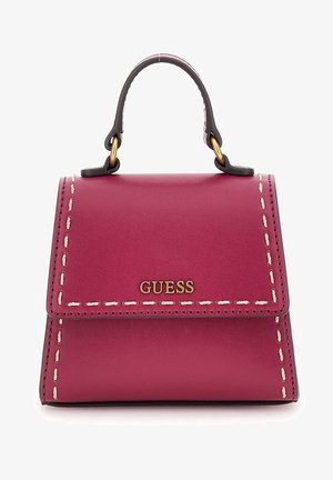 Pequeño bolso de mano de cuero magenta con asa superior, detalles de costuras blancas y logo dorado "GUESS" en la solapa frontal.