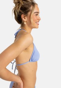 Light blue triangle bikini top with thin ties at the neck and back, featuring a gathered design and smooth fabric texture.