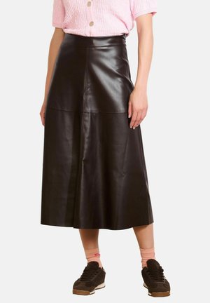 Black leather midi skirt with a smooth texture, featuring a high waist and panel detailing. Paired with brown sneakers and pink socks.