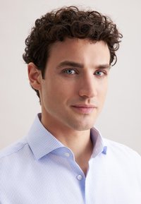 Lichtblauwe gestreepte shirt met knoopkraag en korte mouwen. De stof lijkt glad met een gelijkmatige textuur. Schoon ontwerp, geen aanvullende patronen.