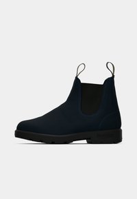 Granatowe botki Chelsea z czarnymi elastycznymi panelami bocznymi, czarną podeszwą i dwoma uchwytami, przedstawione z profilu na białym tle.