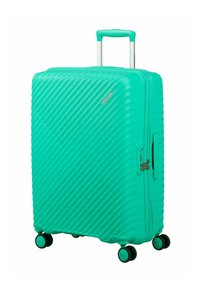 Grande valise rigide turquoise avec des lignes texturées diagonales, quatre roues multidirectionnelles, et une poignée télescopique déployée.