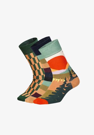Tre par strumpor: gröna och orange geometriska mönster, marinblå med rutigt mönster, och en flerfärgad solnedgångslandskap. Bomullsblandning.