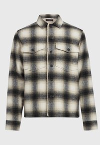 Camisa chaqueta de cuadros en negro, blanco y gris, con cuello, dos bolsillos de solapa en el pecho y forro de tela texturizada en la tapeta de botones.