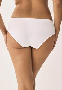 Witte katoenen slip met een gladde textuur, mid-rise ontwerp en een gegolfde rand. De stof lijkt zacht en rekbaar voor comfort.