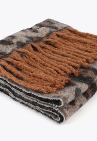 Brun og grå uld tæppe med et tekstureret frynset design, der har en blød overflade og foldede kanter, hvilket skaber et dekorativt mønster.