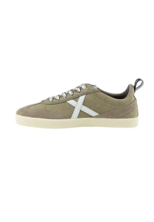 Zapatillas de ante y tela en verde oliva con acentos blancos, cierre con cordones, suela de goma texturizada y tira en el talón para facilitar el uso.
