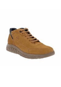 Brązowe zamszowe buty wysokie z podeszwą o fakturze plastra miodu. Posiadają czarne akcenty na pięcie i sznurówkach. Minimalne logo po boku.