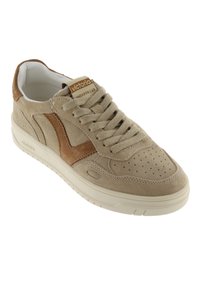 Sneaker in suede beige con un accento in suede marrone, punta rotonda, dettagli perforati, lacci piatti e suola in gomma bianca. Brandizzazione sulla linguetta.