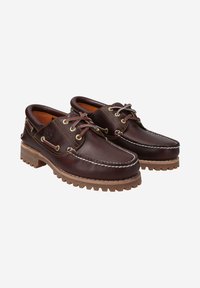 Braune Lederschuhe mit gesticktem Design, ausgestattet mit runden Schnürsenkeln und robusten Gummisohlen. Akzentuiert mit Messingösen und einer strukturierten Oberfläche.
