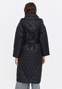 Czarna pikowana kurtka puchowa z kapturem, z paskiem w talii i długimi rękawami. Charakteryzuje się diamentowym wzorem i błyszczącą fakturą materiału.