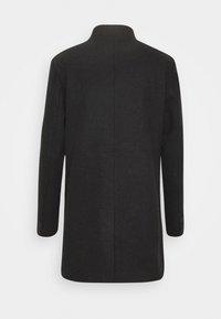 Cappotto lungo in lana nera con collo alto, maniche lunghe e vestibilità sagomata. Presenta un retro dritto senza chiusure o tasche visibili.