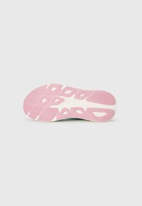 Semelle de chaussure de sport avec une semelle en caoutchouc rose, dotée de motifs texturés et de détails en accent blanc. La surface supérieure est lisse et courbée.