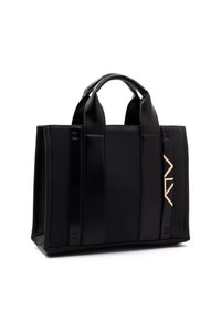 Musta kangaskassi, jossa on sileän nahkaosat ja teksturoitu kangas. Kassissa on kaksi kahvaa ja metallinen logo sivussa.