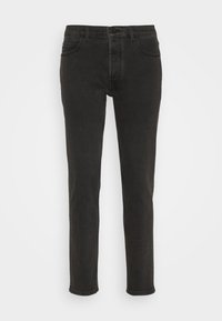 Musta farkut, joissa on kapeahko istuvuus, klassinen viiden taskun malli ja napillinen etuvetoketju. Sileä pinta ja vähäinen haalistuma.