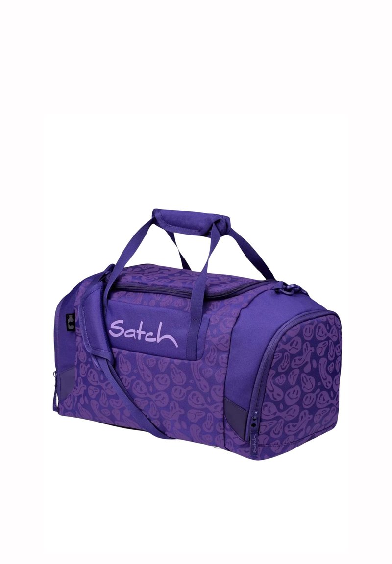 Purple duffel bag with a pattern of smiling faces, featuring dual handles, a shoulder strap, and a zippered closure. "Satch" logo on front.