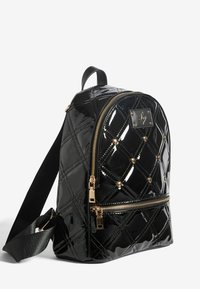 Musthave must värviga lakknahk seljakott, millel on tikanddisain, kuldsed tarvikud, esiküljel lukuga tasku ja kuldsed nurgakujulised kaunistused. Reguleeritav õlarihm komplektis.