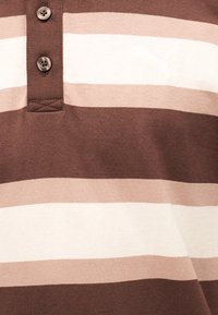 Καφέ και μπεζ οριζόντια ριγέ πόλο μπλούζα με δύο εμφανή κουμπιά και ένα λεπτό κεντημένο λογότυπο Puma στο στήθος.