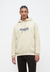 Beige hoodie met een voorzak, versierd met meerkleurige grafische tekst. Gemaakt van zachte katoen en met verstelbare trekkoorden in de capuchon.