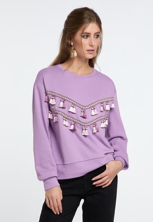Felpa viola con un bordo decorativo con frange in tonalità di rosa e bianco, scollo rotondo e maniche lunghe.