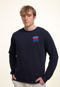 Felpa blu navy, in misto cotone, maniche lunghe, con polsini e orlo a coste, caratterizzata da un logo testuale "PEPSI" colorato sul petto in rosso e blu.