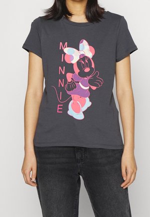 Osoba nosząca ciemnoszarą koszulkę z kolorową grafiką Minnie Mouse i pionowym napisem "MINNIE" na przodzie, w połączeniu z czarnymi jeansami.