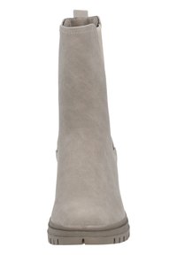 Botín de ante gris con una textura suave, paneles laterales elásticos y una suela de goma plana. Cuenta con una lengüeta en la parte trasera para facilitar su puesta.