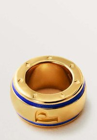 Anillo de oro con un diseño liso y redondeado, que presenta una franja de acento azul y pequeños remaches circulares alrededor del borde exterior.
