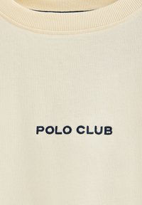 Sudadera color crema con cuello redondo acanalado y "POLO CLUB" bordado en azul marino en la parte frontal, con una textura de tela suave.