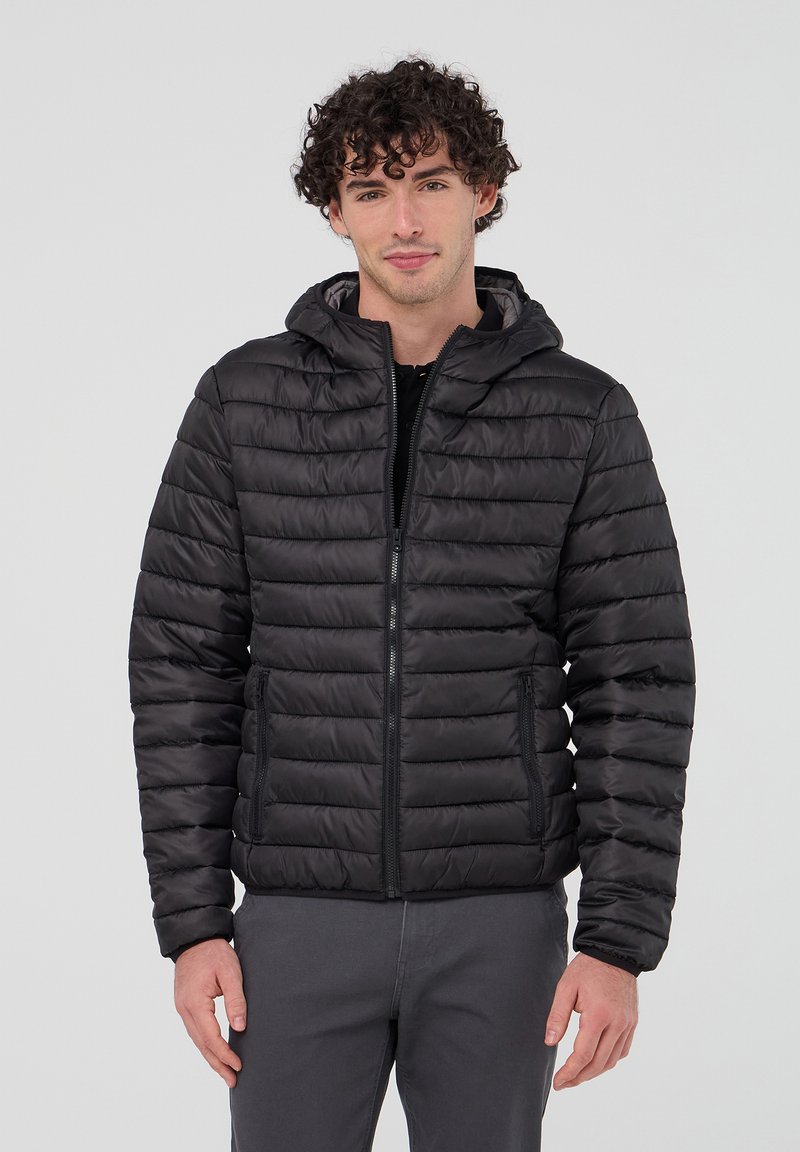 Giacca imbottita nera con cappuccio, design trapuntato, chiusura frontale con zip e due tasche laterali. Texture liscia e materiale leggero.