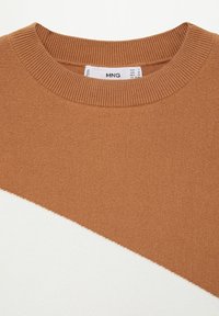 Maglione color block marrone e bianco con collo a girocollo a coste, texture in maglia morbida e un design angolato sul davanti. Etichetta del marchio visibile.