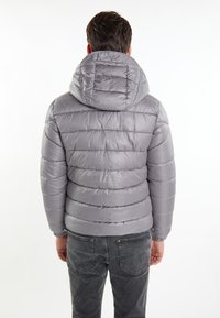Giubbotto imbottito grigio, design trapuntato con cappuccio, polsini elastici e superficie liscia. Leggero e compatto, adatto per il freddo.