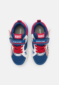 Blå og hvide mesh sportsko med røde detaljer, en Velcro-rem og Marvel-branding. Har et cirkulært grafik på siden.