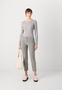 Lys grå ripede langermede topp, teksturerte grå tweedbukser, beige veske og bleke loafere med mørke såler. Enkel, skreddersydd design gjennomgående.