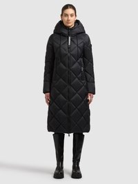 Sort, quiltet lang frakke med hætte, der har en lynlås foran, sidelommer og et struktureret diamantmønster. Kombineret med knæhøje sorte støvler.