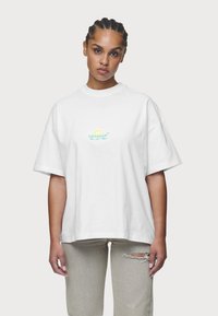 Weißes Baumwoll-T-Shirt mit lockerer Passform, kurzen Ärmeln und rundem Ausschnitt. Mit einem mehrfarbigen Logo-Graphic auf der Brust.