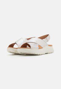 Zilveren sandalen met kruisbanden, open teen en hiel, met een lichtgekleurde zool met structuur en een gevoerde binnenzool.