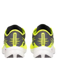 Zapatillas deportivas amarillas y negras con parte superior de malla transpirable, media suela blanca acolchada y talón texturizado gris. Acentos reflectantes visibles.