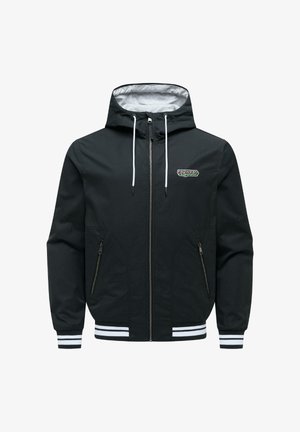 Zwarte zip-up jas met capuchon, witte trekkoorden, twee voorzakken met rits, geribbelde boorden en zoom met witte strepen, en een klein "ragwear" logo.