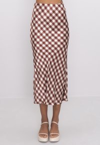 Ruskea-valkoinen ruudullinen midi-hame, jossa on sileä kangas, vartalonmyötäinen vyötärön kohdalla, liehuva helma ja hienovarainen tekstuuri. Yhdistetty korokepohjakenkiin.