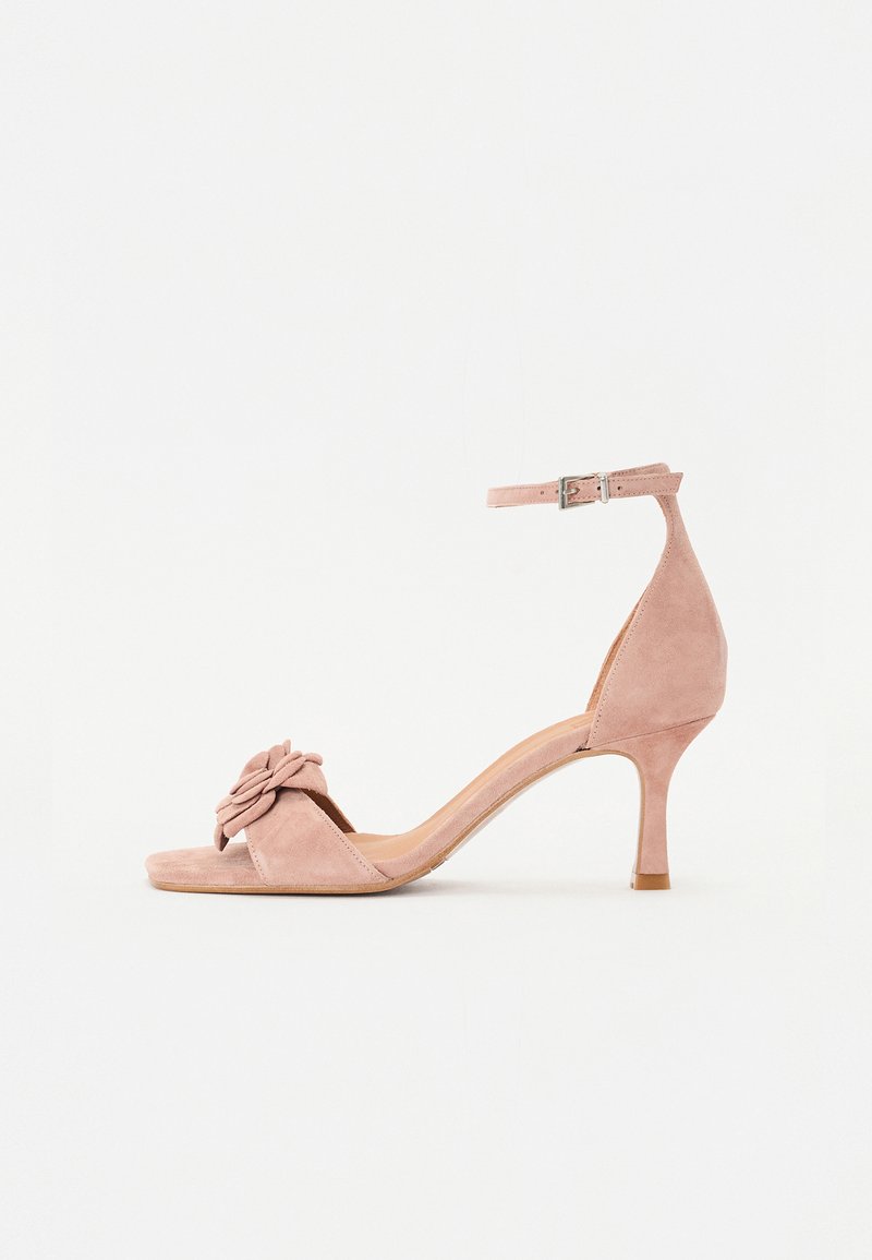 Suede, ροζ σαμπανιζέ ψηλοτάκουνα σανδάλια με λουράκι στον αστράγαλο, ανοιχτή μύτη και διακοσμητικό λουλούδι μπροστά. Λείο υλικό και κομψό σχήμα.