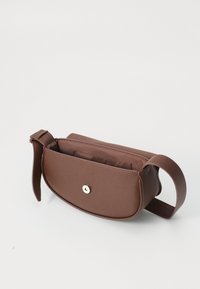 Bruine leren tas met een gladde textuur. Ovale vorm, voorkant met drukknoopsluiting en een zijhandvat. Interne vak zichtbaar.