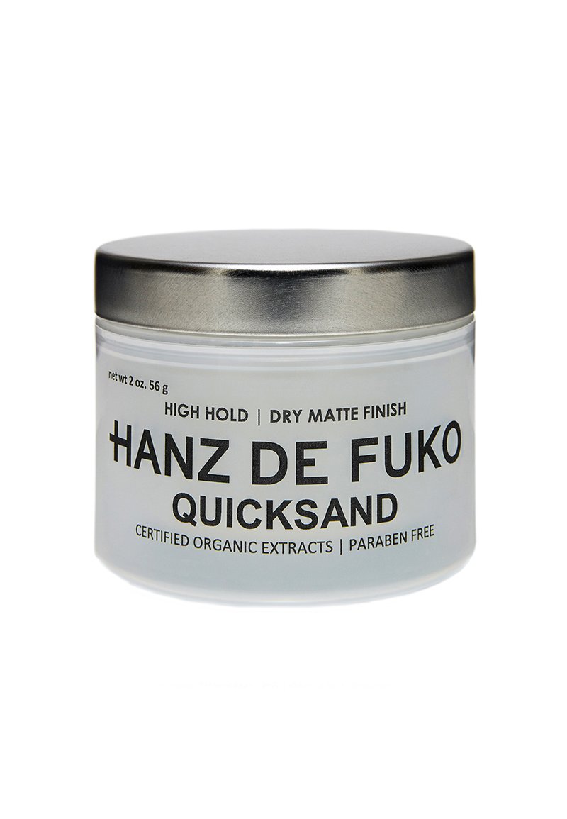Klart glasskrukke med et sølvfarget metallokk. Etiketten har fet svart tekst. Inneholder 2 oz (56 g) av et hårprodukt med høy hold, tørr matt finish. Fri for parabener.
