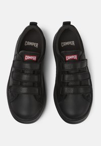 Baskets noires en cuir et matériau synthétique, avec trois bandes Velcro, bout rond et intérieur rembourré avec le logo de la marque.