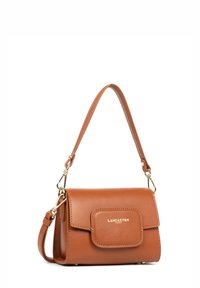 Braune Lederhandtasche mit einem einzelnen Tragriemen, abnehmbarem Gurt, magnetischem Klappenverschluss und goldfarbenem Logo-Akzent auf der Vorderseite.